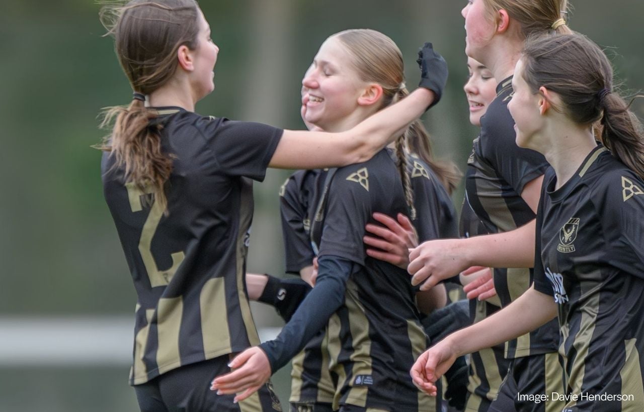 Women’s football players celebrating in fitted custom women’s football kits
